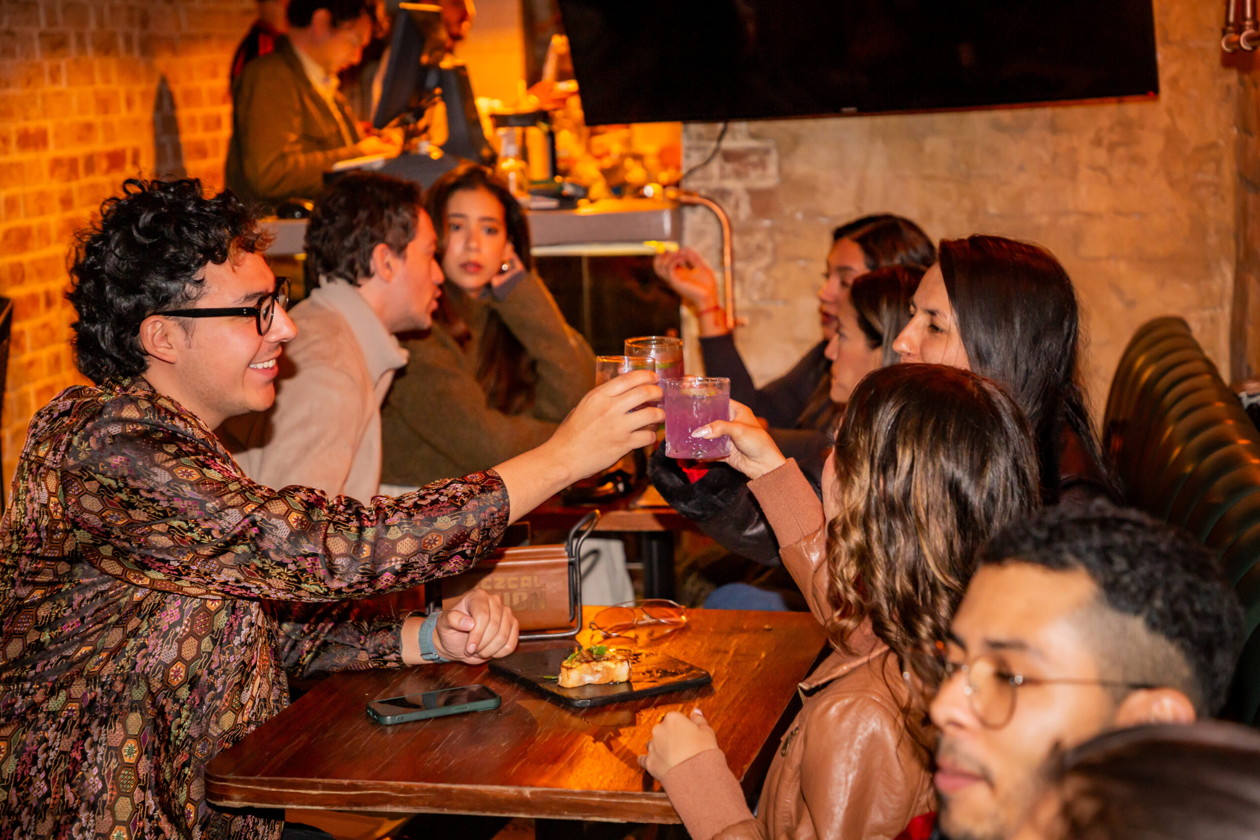 3 personas brindan en la mesa